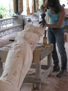 Artiste en train de sculpter du bois au festival Camille Claudel à La Bresse